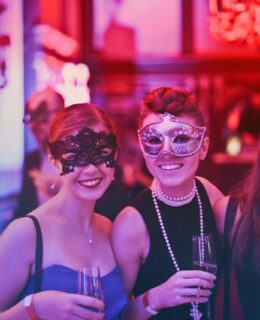 Tre kvinder har masker på til kostumefest